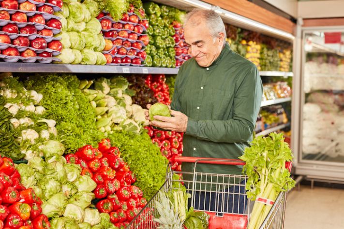 Senior man keeping a healthy diet in mind while shopping in a grocery store.