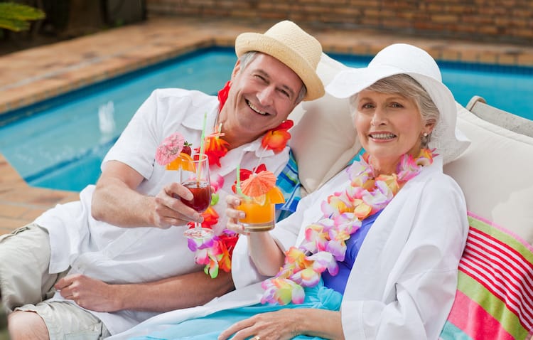 Senior couple enjoying a cocktail by the pool.