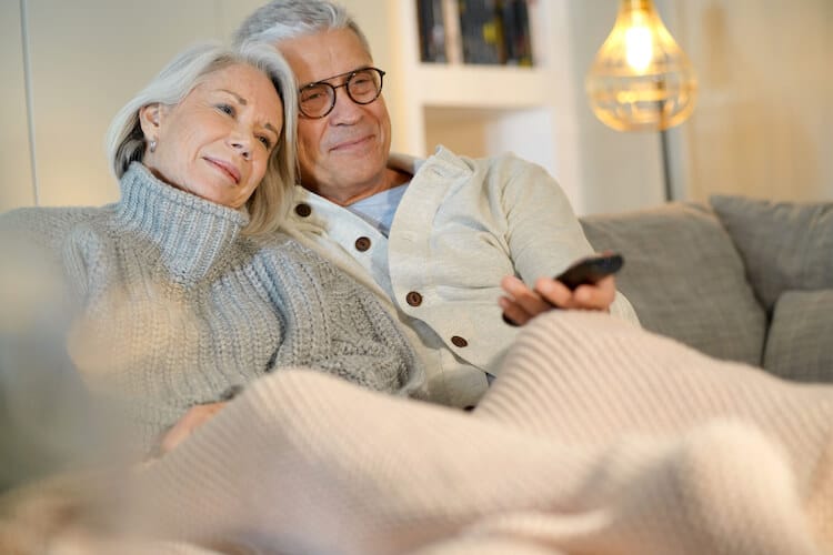 Senior couple at home during the winter relaxing and watching TV.