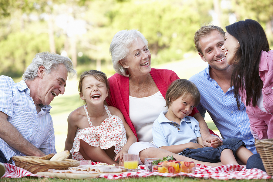 A multi-generational family enjoys an outdoor picnic on a sunny Spring afternoon