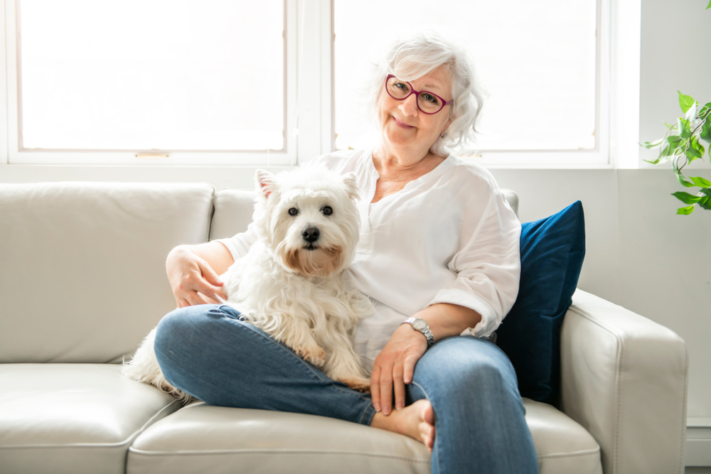 A senior woman and a dog on a couch