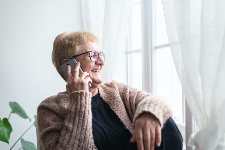 Senior woman using cell phone technology to stay socially connected.