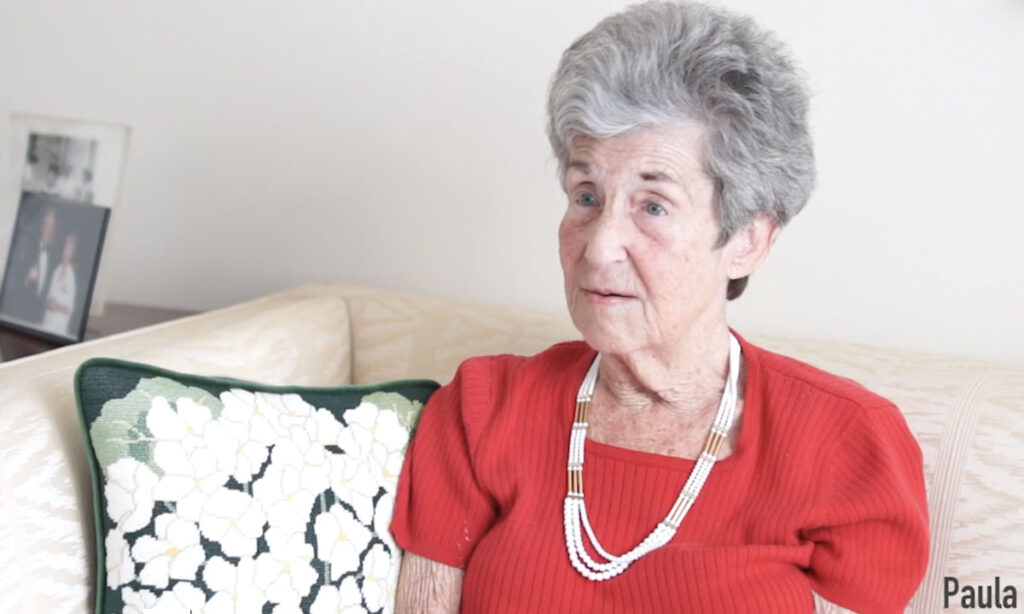senior woman in red blouse and white necklace