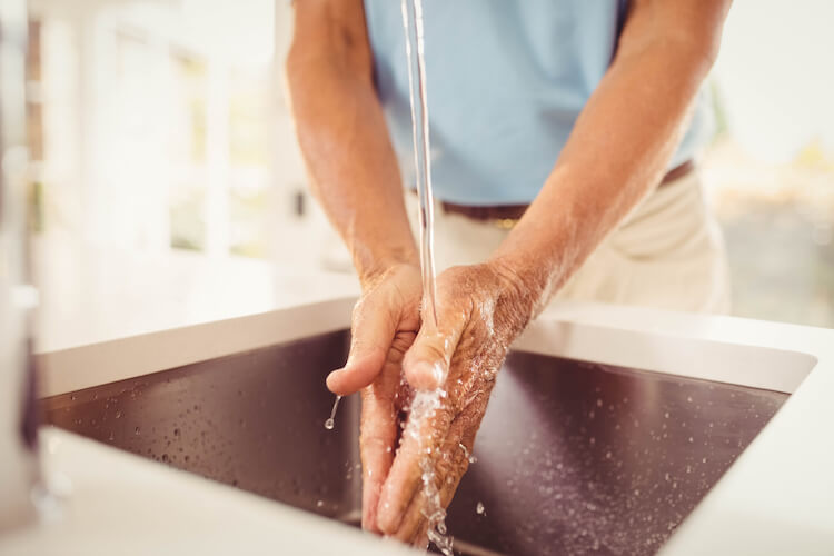 Senior washing their hands in order to maintain good personal hygiene.