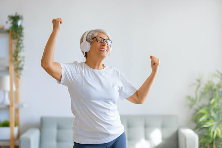 Senior woman exercising in her home by dancing.
