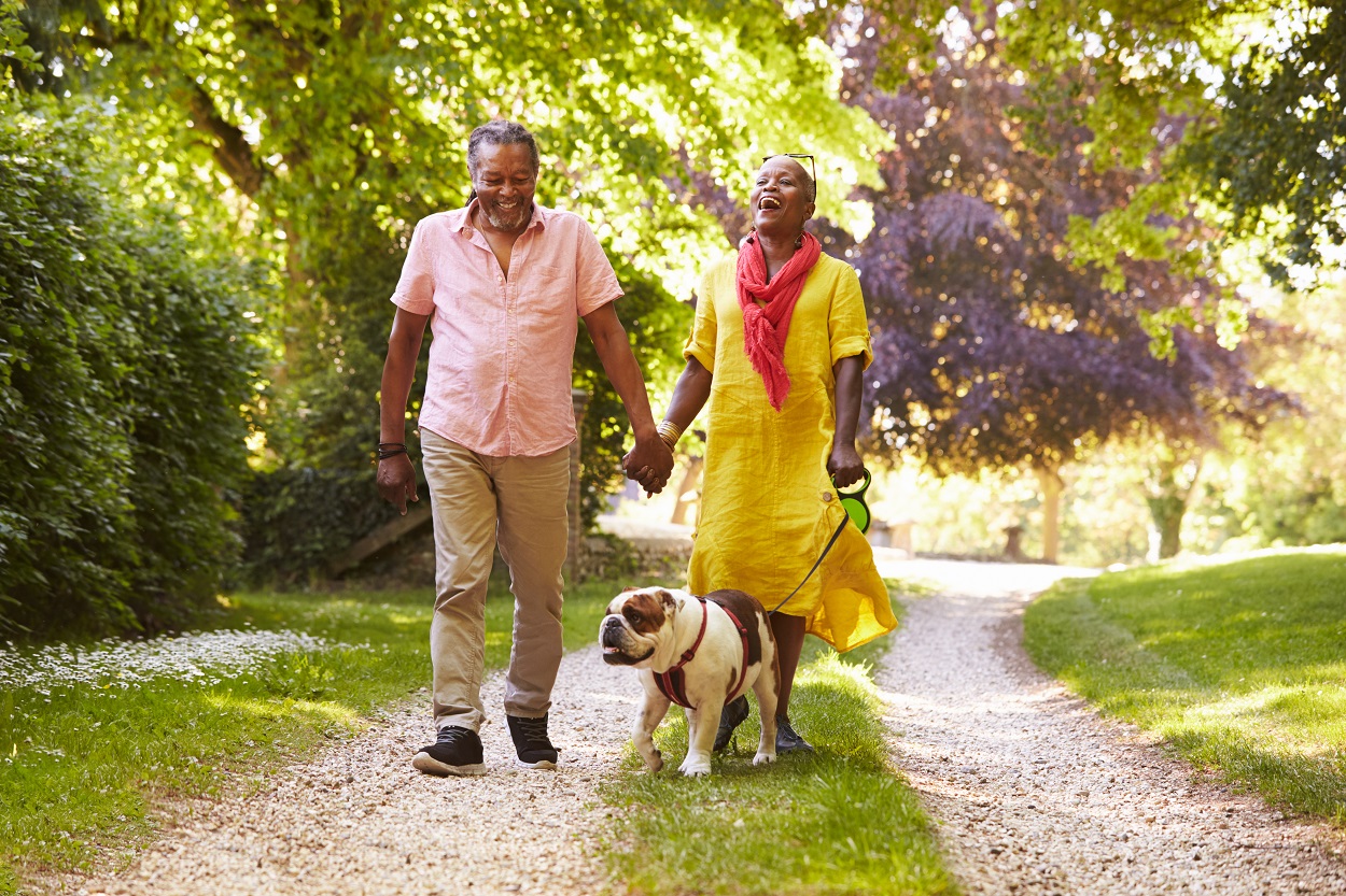 senior couple enjoying an outdoor walk with dog