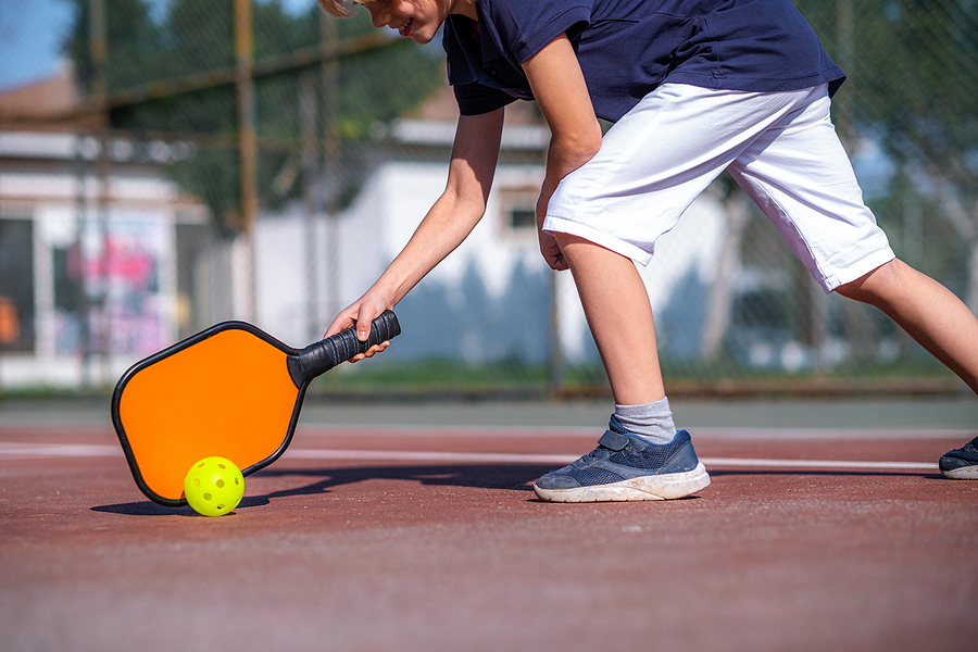 A senior man plays pickleball.