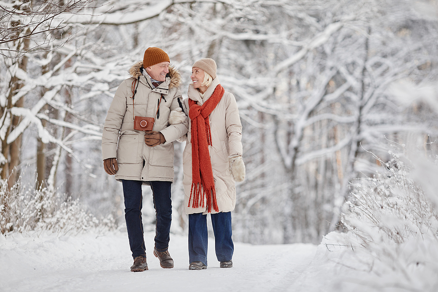 Senior couple fights the winter blues by taking a snowy stroll