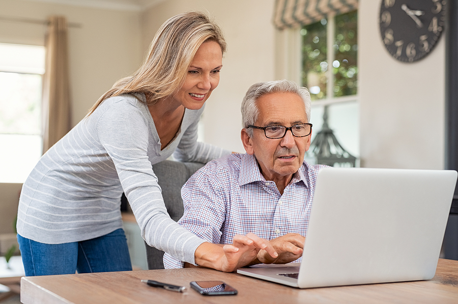 Adult daughter helps senior father look at floor plans