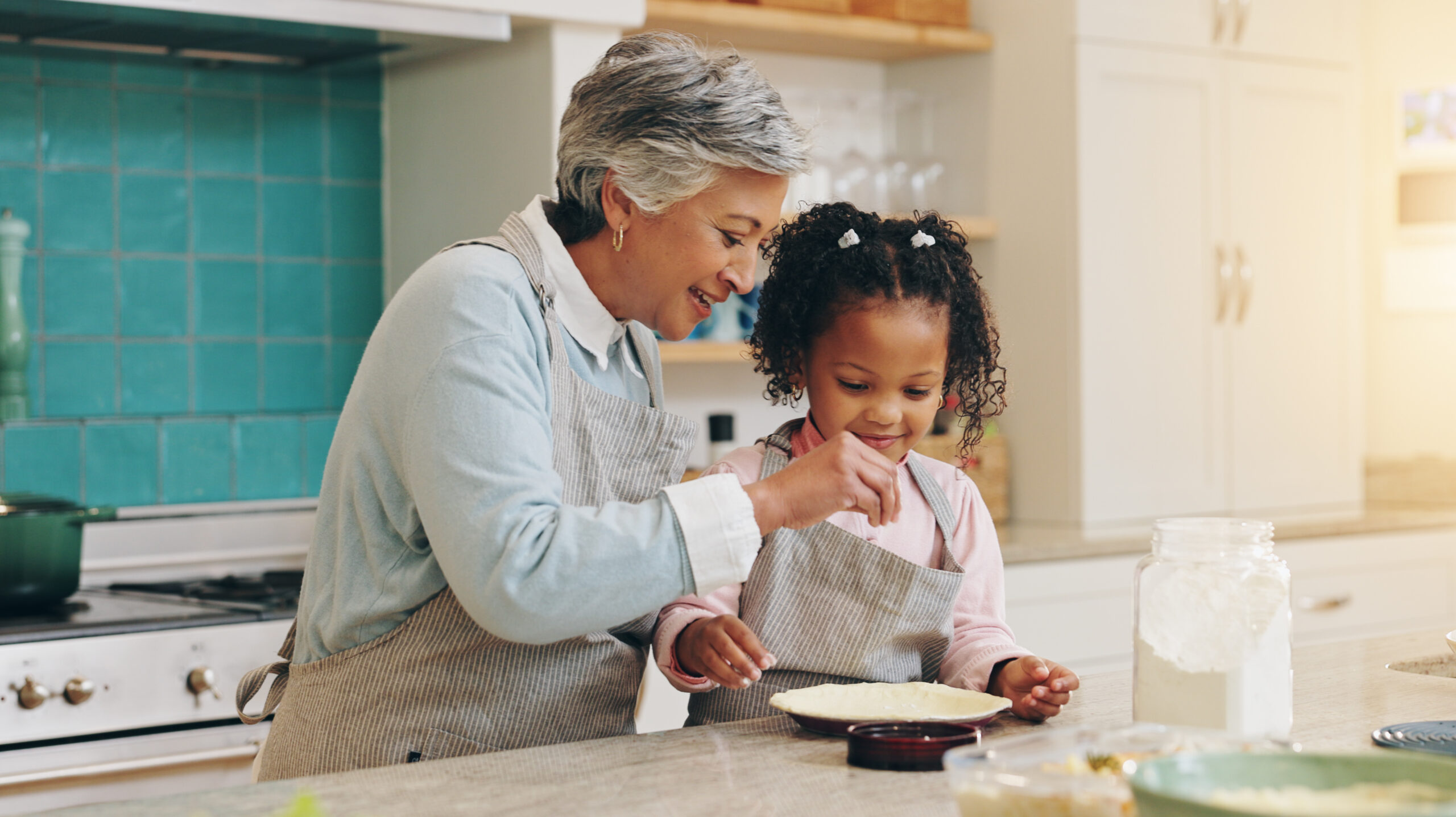 Senior woman baking in a kitchen with granddaughter